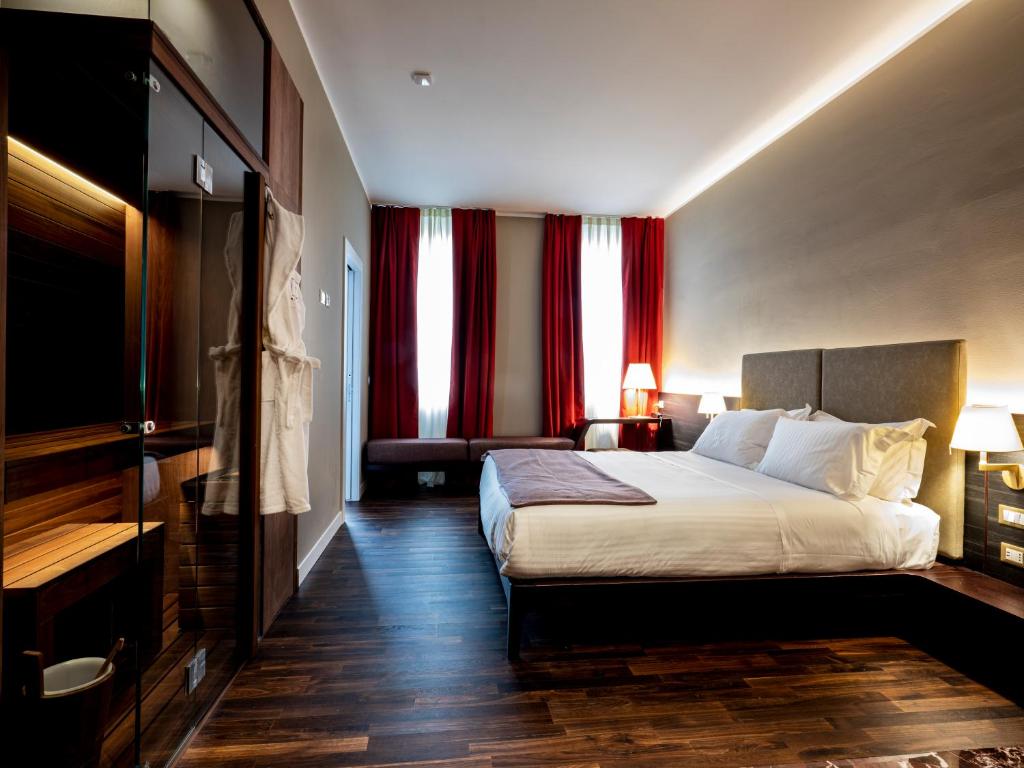 a hotel room with a large bed and red curtains at 10 KEYS MILANO in Milan