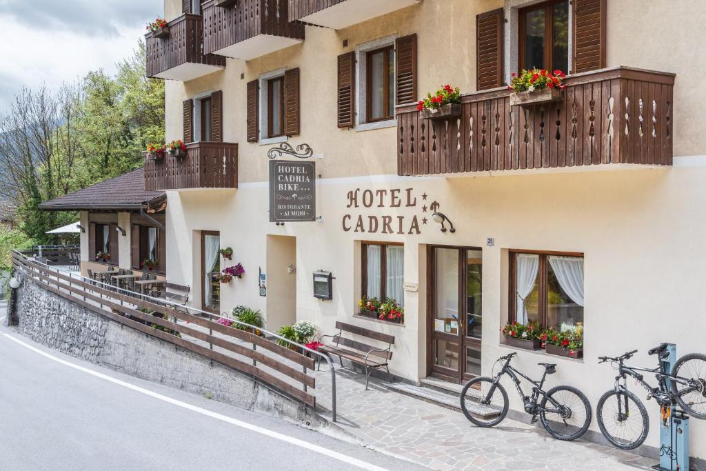 ein Gebäude mit zwei Fahrrädern, die draußen geparkt sind in der Unterkunft Cadria Nature & Bike Hotel in Lenzumo di Concei