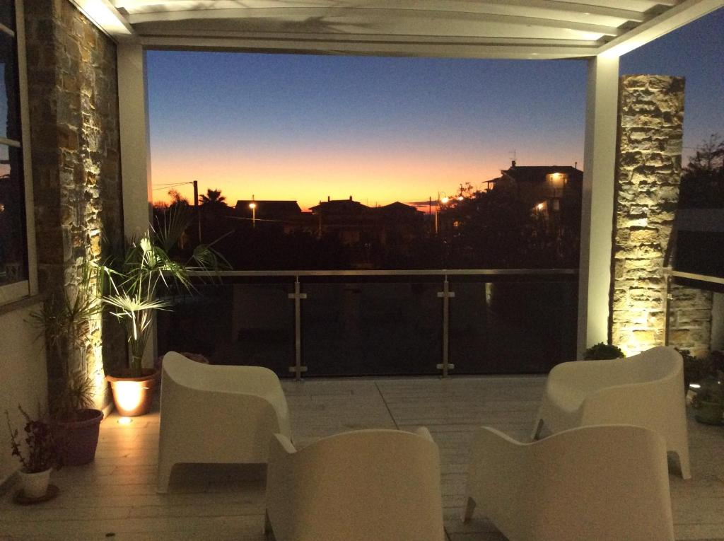balcón con sillas y vistas a la puesta de sol en Laris, en Castellabate