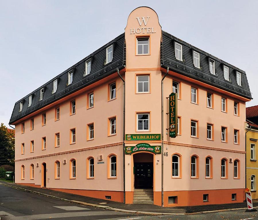 a large building with a clock on the front of it at Hotel Weberhof in Zittau