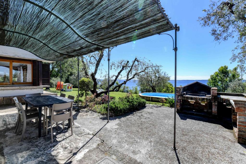 une terrasse avec une table et une piscine dans l'établissement Casa Raffaella -Ciao Vacanze-, à Moniga del Garda