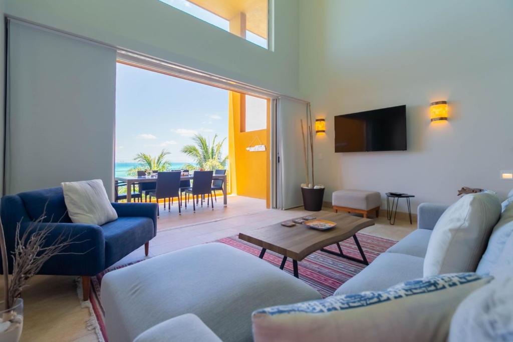 sala de estar con sofá, sillas y TV en Isla Sunset Rentals at Sotavento en Isla Mujeres