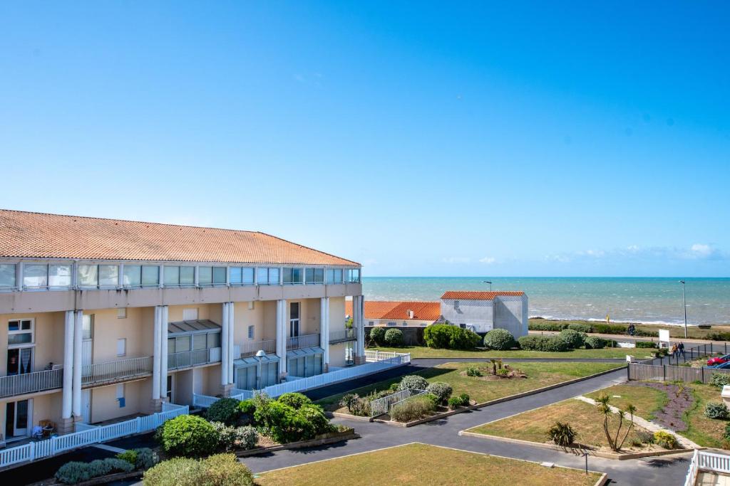 an apartment building with the ocean in the background at Emplacement idéal - Trou du Diable sur la Corniche in Les Bussolleries