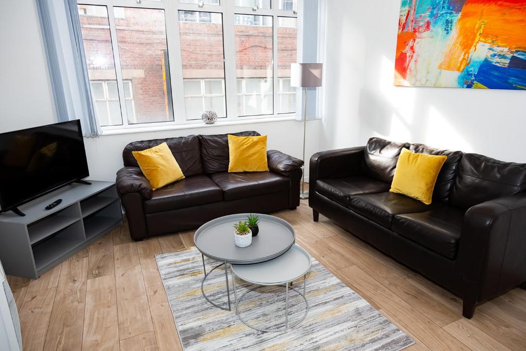 uma sala de estar com dois sofás de couro e uma mesa em Alexander Apartments Powdene House em Newcastle upon Tyne