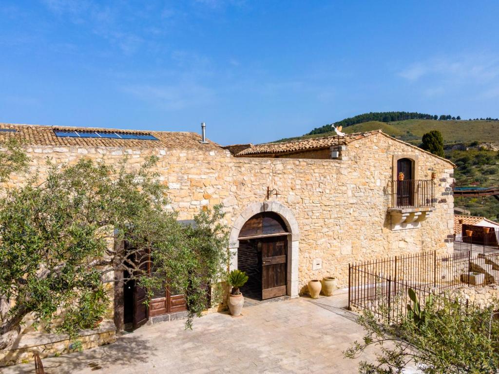 un gran edificio de piedra con puerta y patio en Masseria Fortificata Lo Zafferaneto, en Buccheri