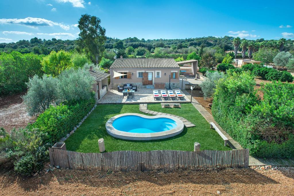 una vista aérea de un patio trasero con piscina y una casa en Owl Booking Villa Garreta - Rustic Stay with Mountain Views, en Campanet