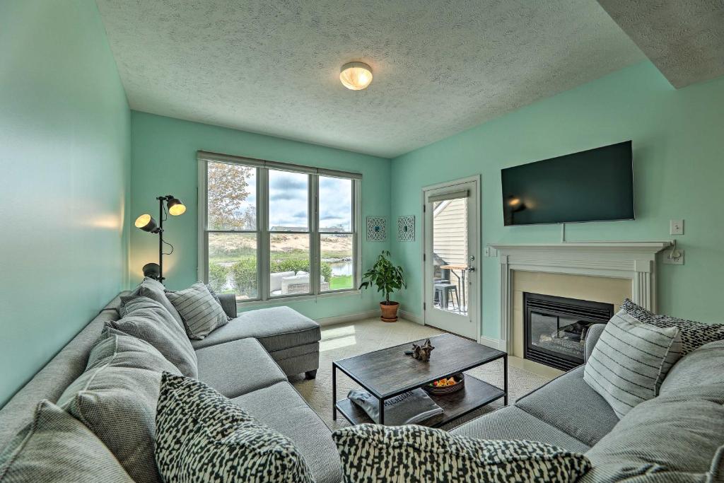 a living room with a couch and a fireplace at Bright, Beautiful Manistee Condo Near Beach and Pool in Manistee