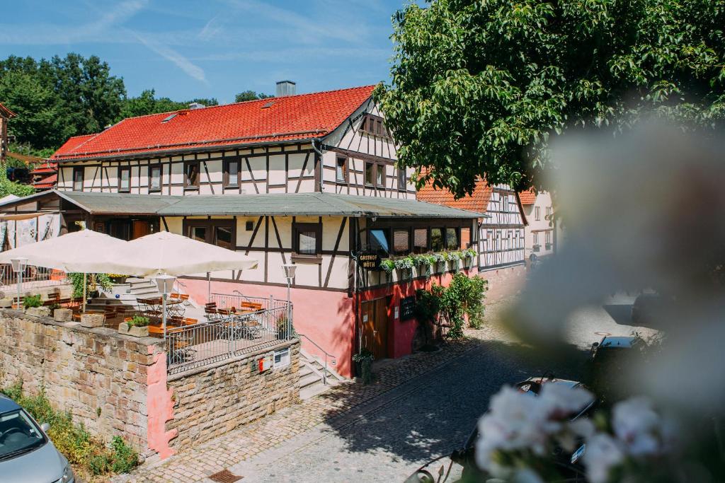 a building with a red roof and aasteryasteryasteryasteryasteryasteryasteryastery at Hotel Restaurant Nöth in Hammelburg