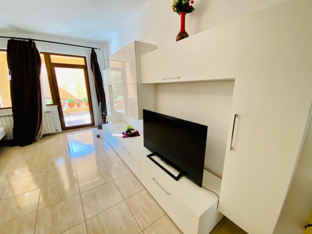 sala de estar con TV de pantalla plana en una pared blanca en Apartament Central, en Constanţa
