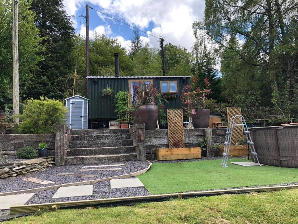 a backyard with a tiny house and a playground at Betws View, Shepherd Hut in Betws-y-coed