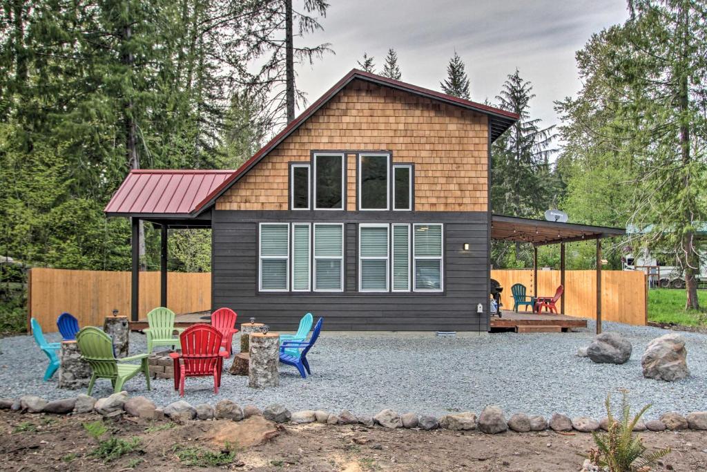 a tiny house with colorful chairs in front of it at Cozy Cabin - 5 Miles to Mt Rainier National Park! in Ashford