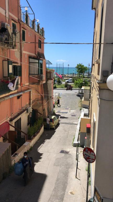 Une allée avec des bâtiments et un homme assis dans la rue dans l'établissement Amalfi Coast Casa Ida, à Vietri