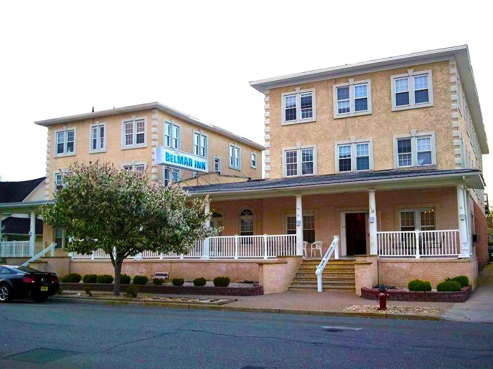 un gran edificio de ladrillo con un coche aparcado delante de él en The Belmar Inn, en Belmar