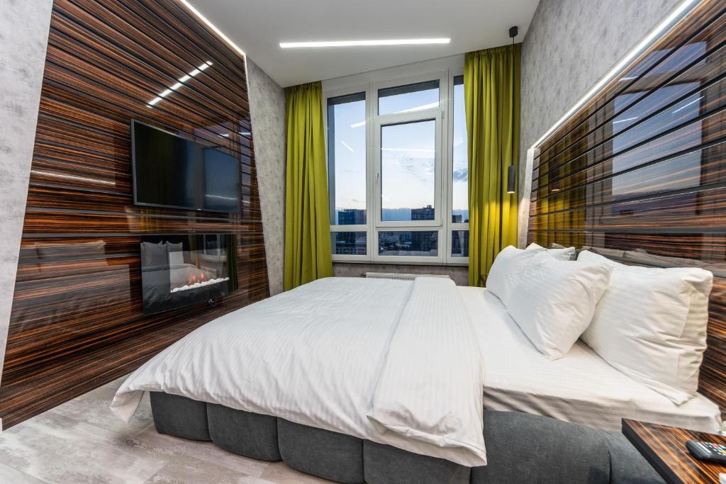 Luxury Apartments in Downtown في كييف: غرفة نوم بسرير كبير وتلفزيون