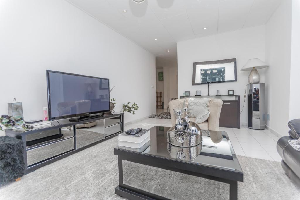 a living room with a tv and a couch at Appartement à 700m gare centrale/plage in Pointe-Noire