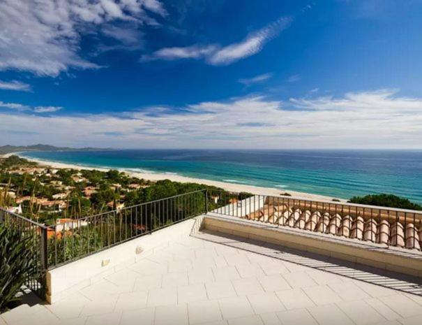 a balcony with a view of the ocean at Magnificent Villa: SUPER PANORAMIC in Costa Rei