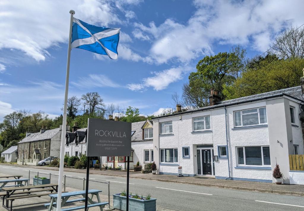 a blue and white flag in front of a building at Rockvilla Guest House in Lochcarron