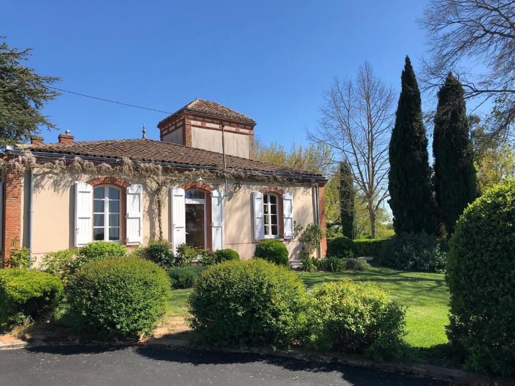 une maison avec des arbres et des buissons devant elle dans l'établissement La Tarabelloise, à Tarabel
