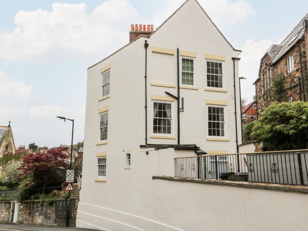 a white house with a white wall at Trillo House in Whitby