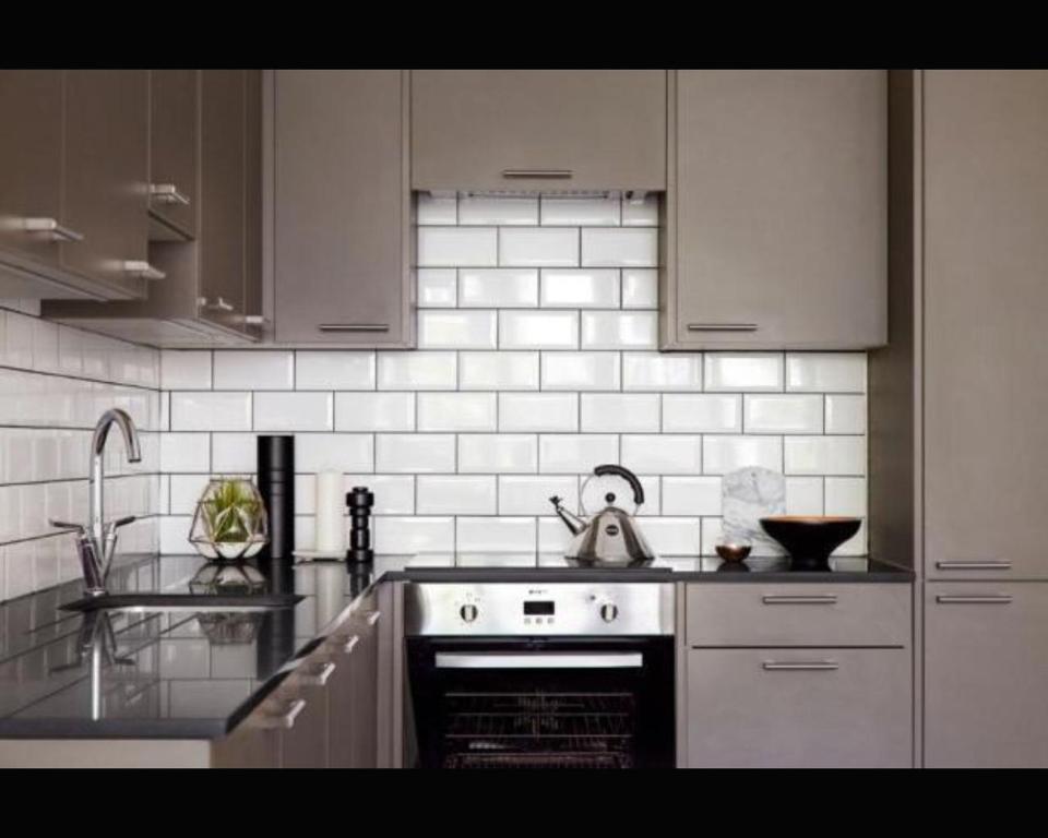 a kitchen with white appliances and a stove top oven at Southernhay Court Apartments by Staytor Accommodation in Exeter