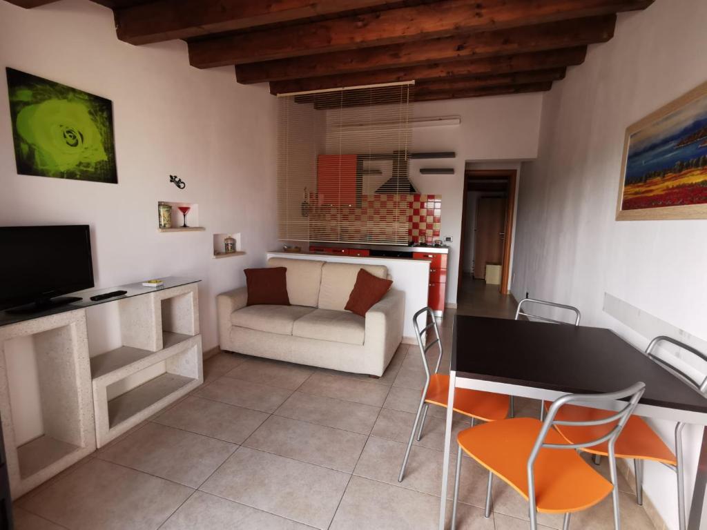 sala de estar con sofá, mesa y sillas en Appartamento Geco Rosso, en Marina di Noto