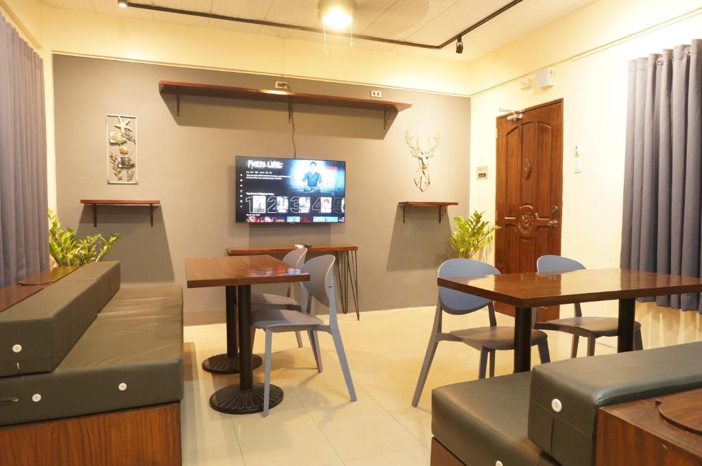 un restaurante con 2 mesas y TV en la pared en Mint Homes in CEV Mansion en Manila