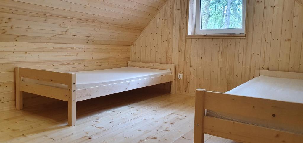 a room with two beds in a wooden cabin at Domki u Remika in Pobierowo