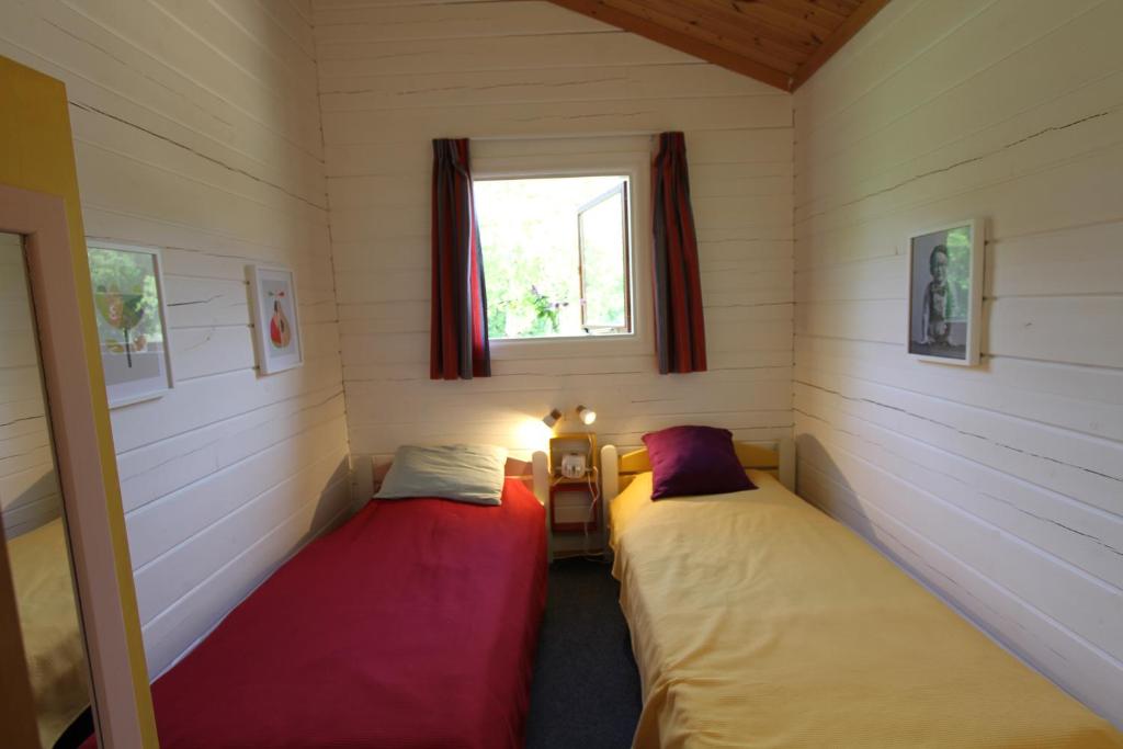 two beds in a small room with a window at Charmant Chalet LE DAMELI, Village du Soleil, Chalet 61 in Mauroux