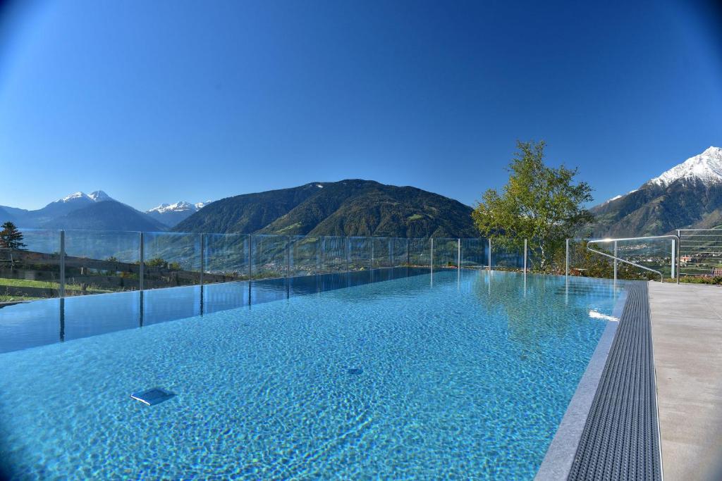 una gran piscina con montañas en el fondo en Residence Wiesenhof, en Scena