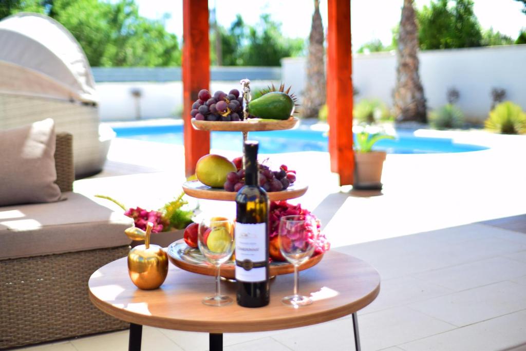 eine Flasche Wein auf dem Tisch mit Obst in der Unterkunft Villa Golden Apple in Seline