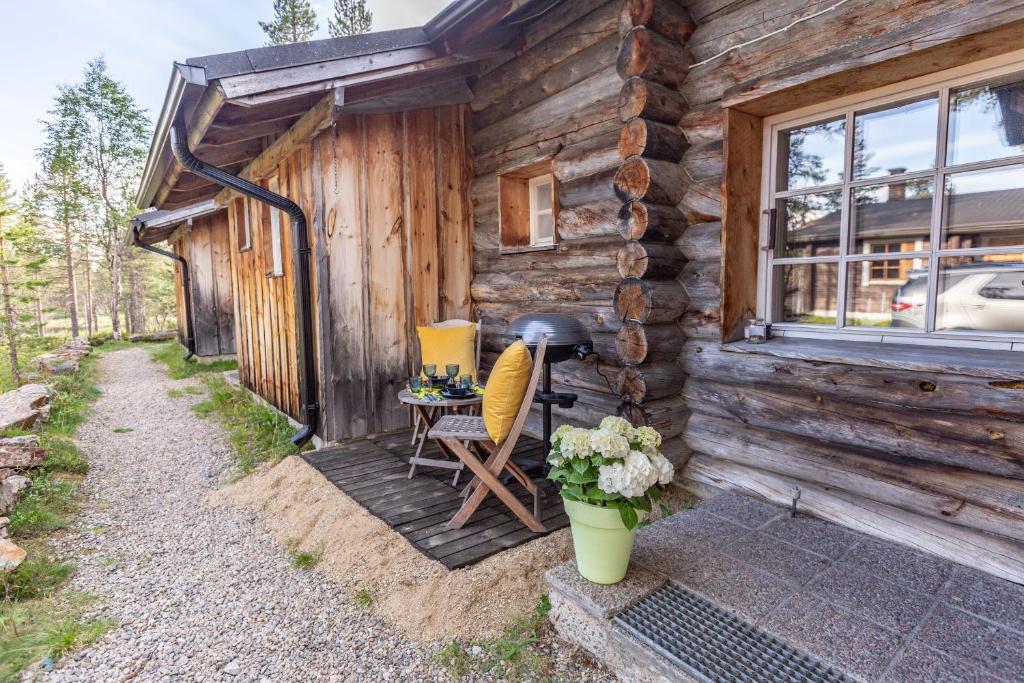 una cabaña con una mesa y sillas fuera de ella en Kuukkeli Apartments Tokka, en Saariselkä