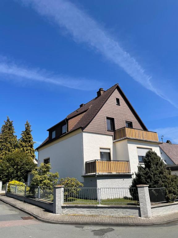 una grande casa bianca con tetto nero di Gemütliche Dachgeschosswohnung a Aßlar