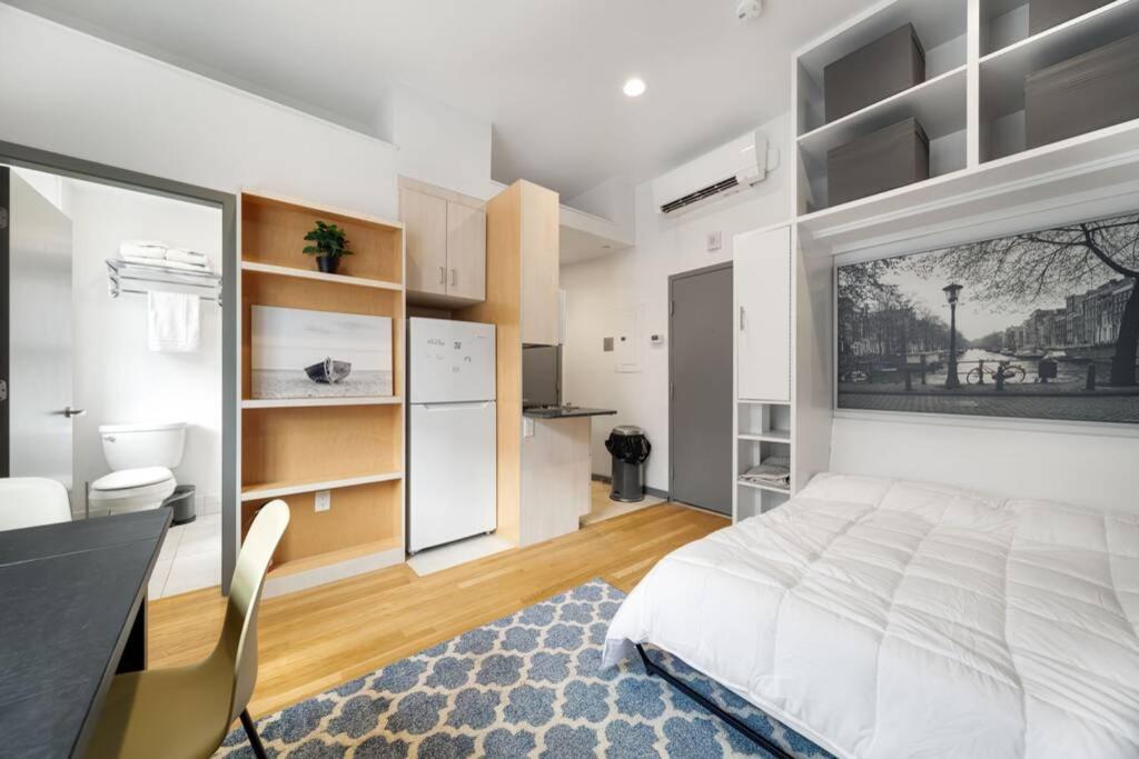 a bedroom with a bed and a desk and a kitchen at Simple Furnished Studio in The Heart of Boston in Boston