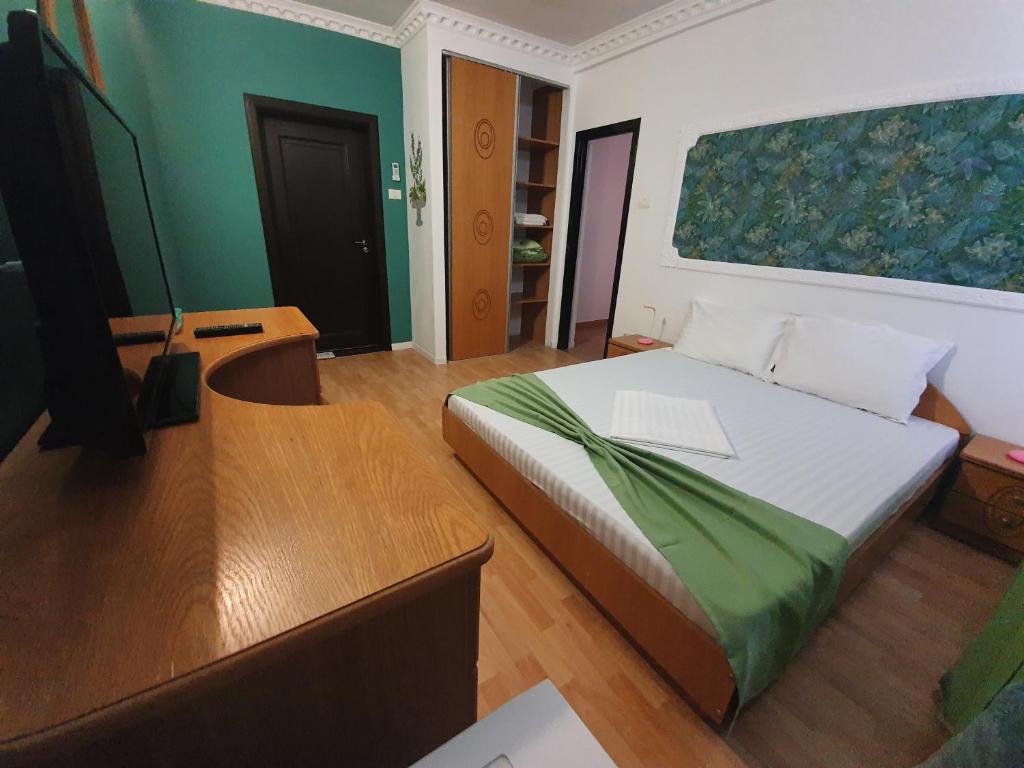 a bedroom with a bed with a desk and a tv at Villa ANelu in Mamaia Sat/Năvodari