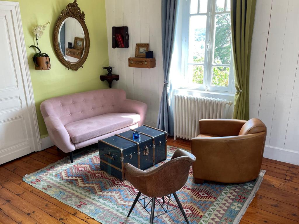 ペリグーにあるChambres d'Hôtes Couleurs du Tempsのリビングルーム(ピンクのソファ、椅子付)