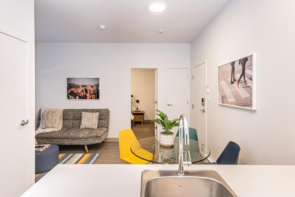 una cucina e un soggiorno con lavandino e divano di New Urban and Well Located 1 Bedroom Apartment by Den Stays a Montréal