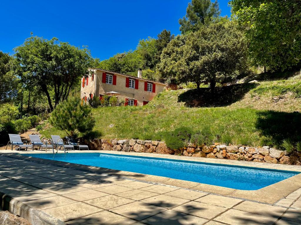 a swimming pool in front of a house at Holiday Home Villa St Arnoux in Seillans