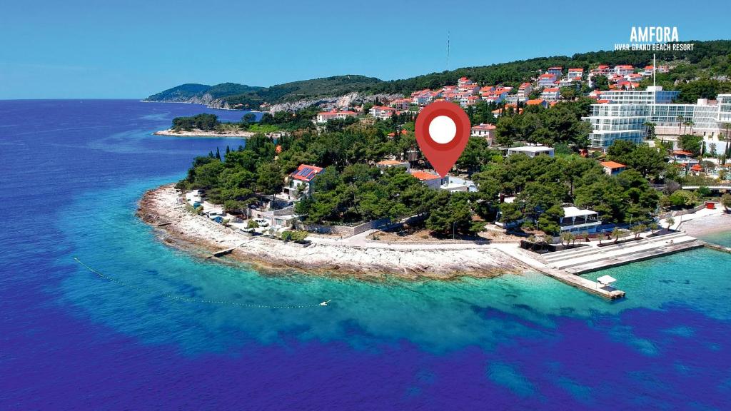 eine Insel mit einem roten Marker im Wasser in der Unterkunft Beach Residences Caroline in Hvar