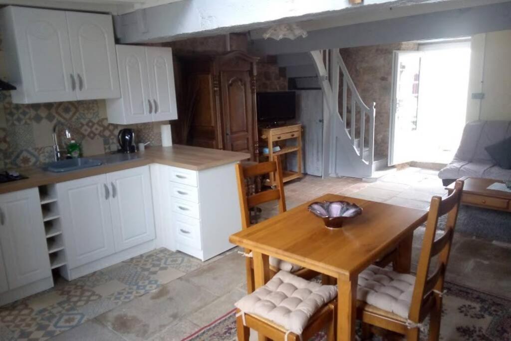 une cuisine avec des armoires blanches et une table en bois dans l'établissement Idéal pour les amoureux de la pierre intérieure, à Palluau