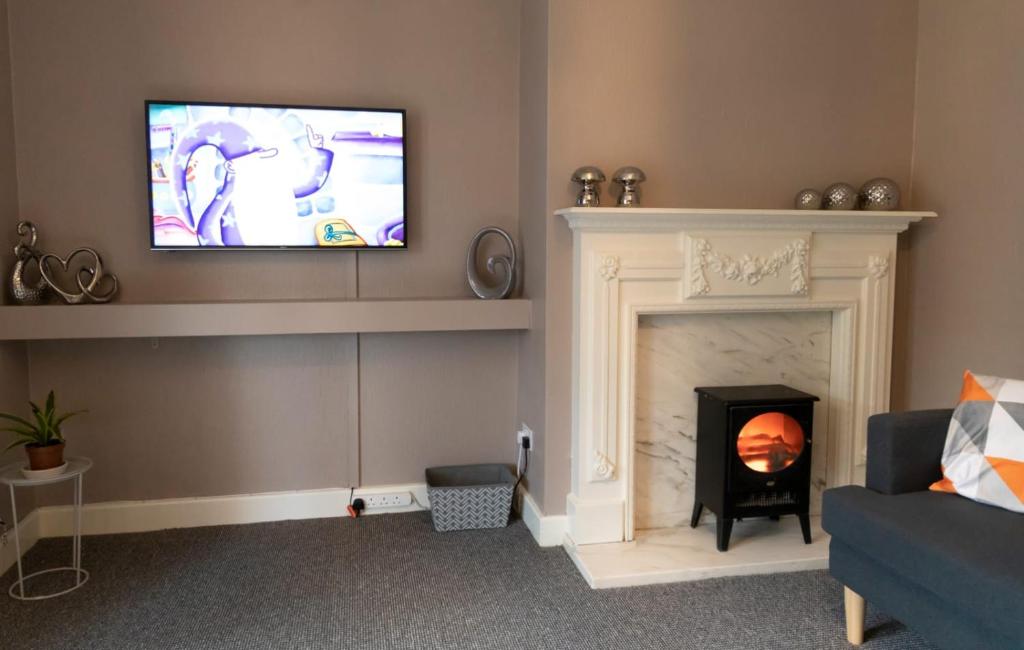 uma sala de estar com uma televisão por cima de uma lareira em Abercorn Place Entire House 4 Bedrooms em Scunthorpe