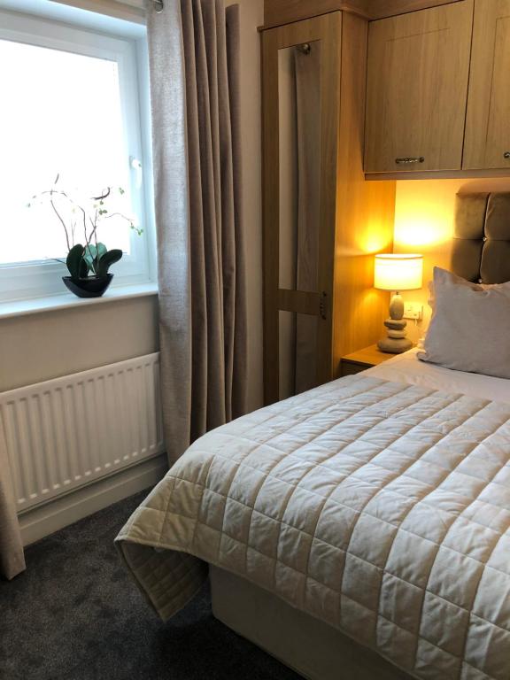 a bedroom with a large bed and a window at Westlea Guest House in Alnmouth