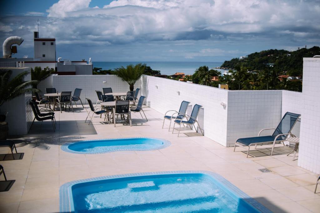 einen Pool auf einer Terrasse mit Stühlen und einem Tisch in der Unterkunft Safira 306 - 150 mts da praia in Ubatuba