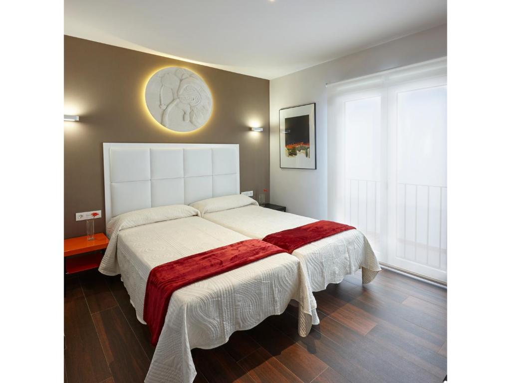 1 dormitorio con 1 cama blanca grande con manta roja en Apartamentos Caballerizas Granada con parking gratuito en pleno centro, en Granada