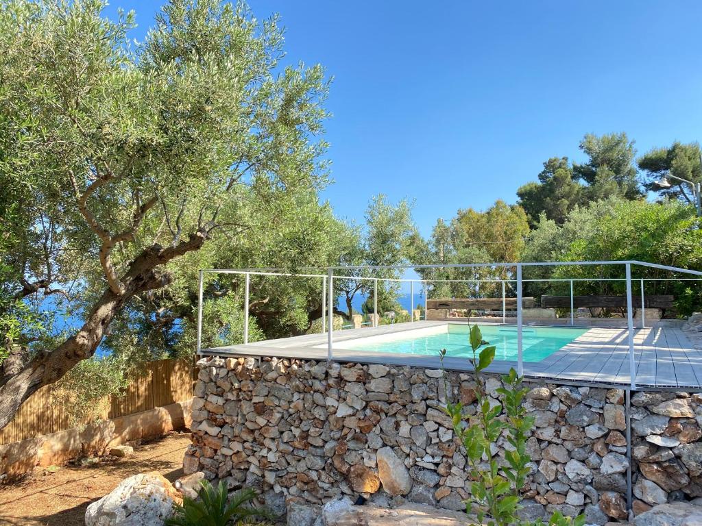 une piscine dans un mur de pierre à côté d'un mur de pierre dans l'établissement Villa Aurora, à Corsano