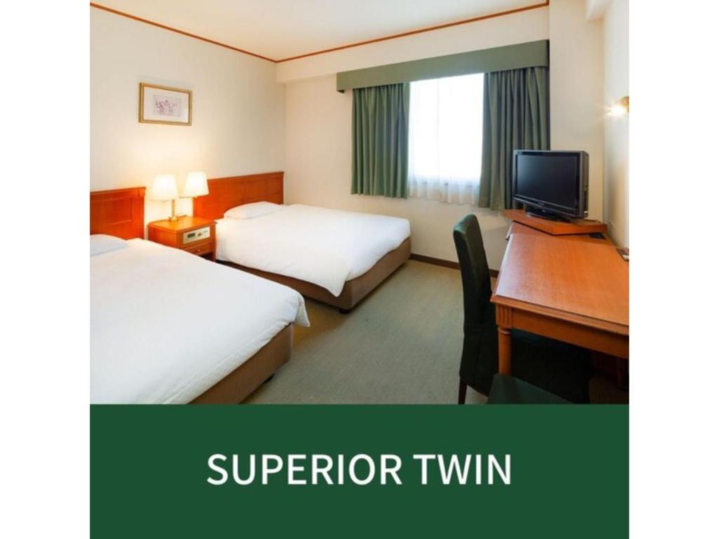 福岡的住宿－Plaza Hotel Premier - Vacation STAY 40093v，酒店客房设有两张床和一张带电脑的书桌