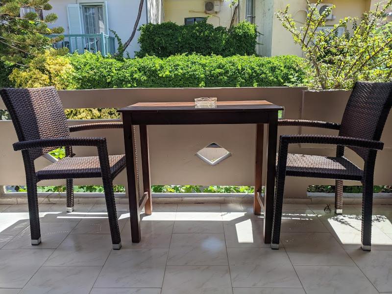 a wooden table and two chairs on a patio at Pension Irene in Sougia