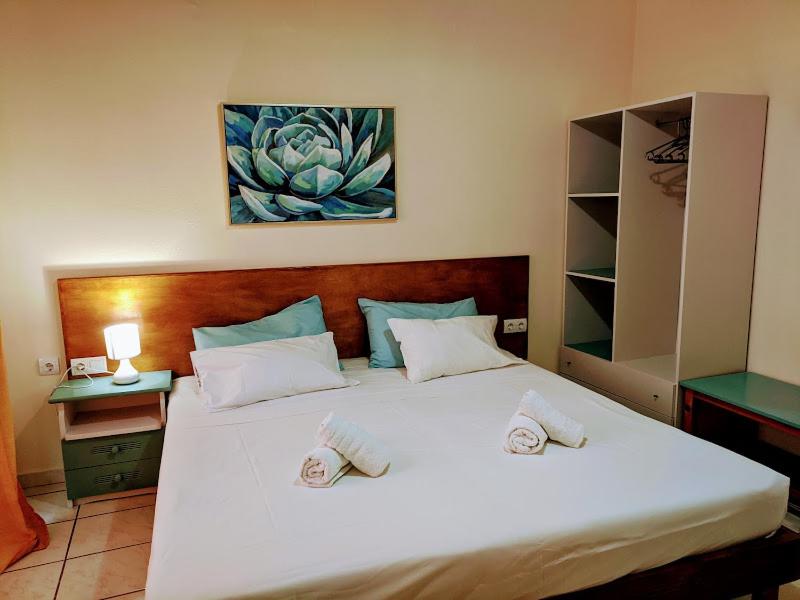 a bedroom with a large white bed with two pillows at Pension Irene in Sougia