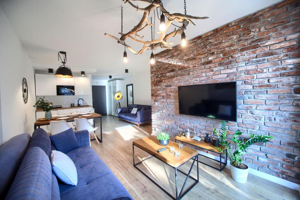 a living room with a blue couch and a brick wall at Apartament AP30 in Mielno