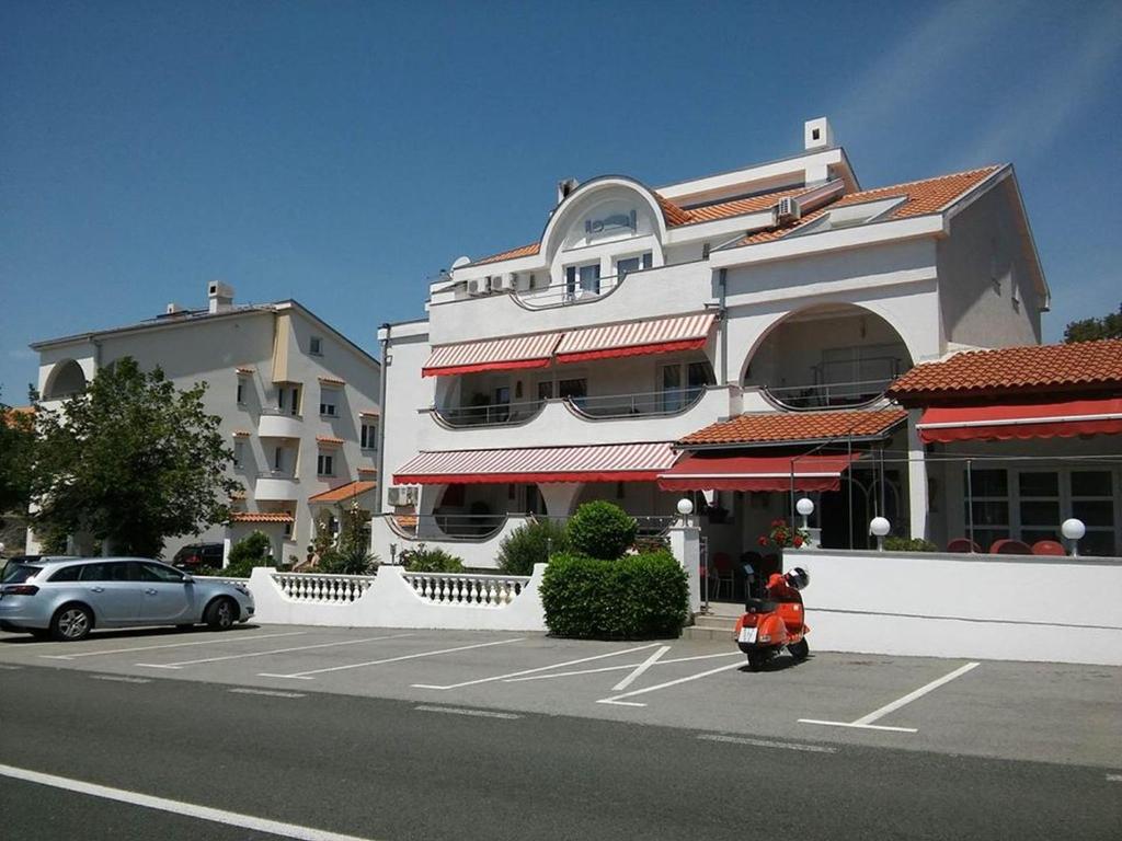 uma scooter estacionada num parque de estacionamento em frente a um edifício em Garfild 1 Guest House em Novi Vinodolski