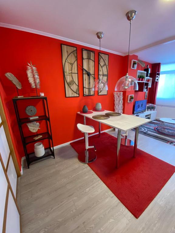 Apartamento Centro Frente Muralla 2 في لوغو: مطبخ مع طاولة وجدار احمر